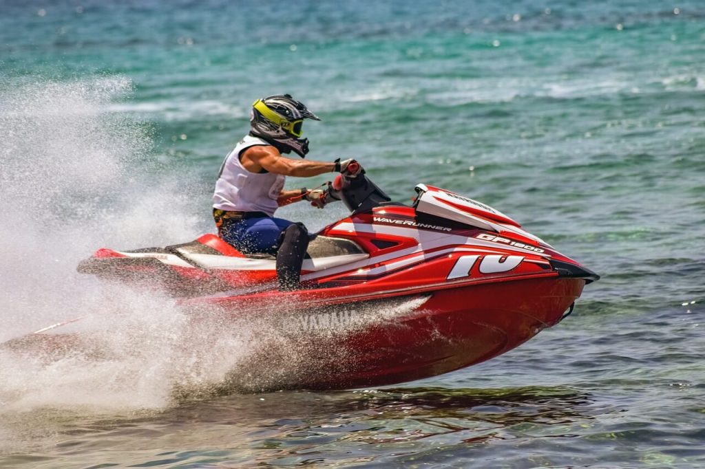 a person riding a red jet ski