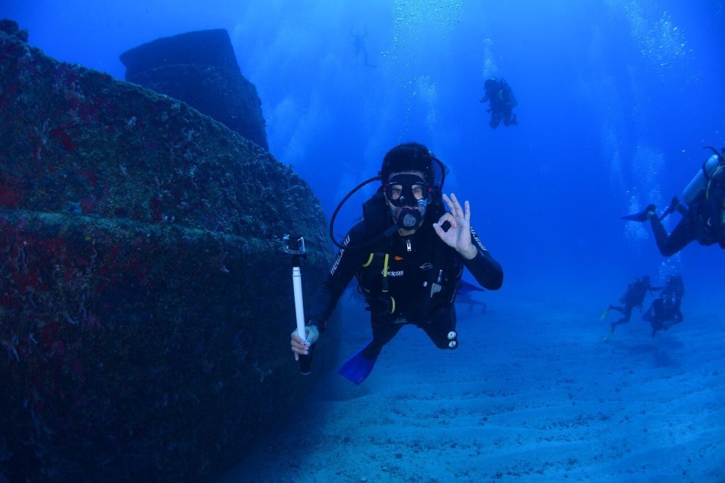 a scuba diver next to a wrecked ship