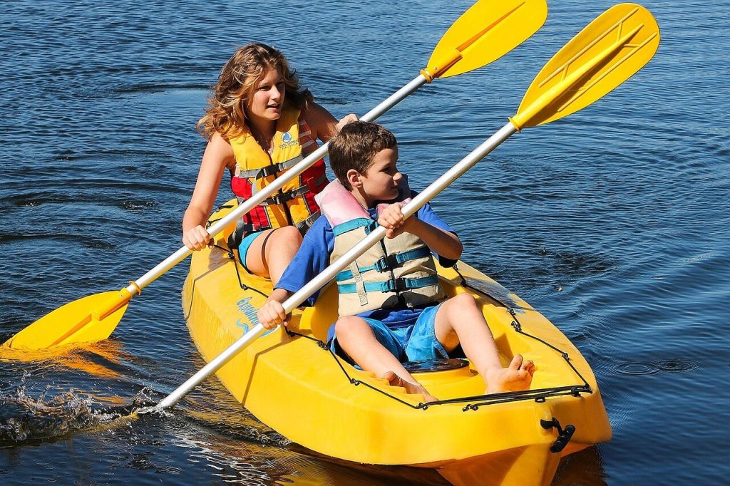 two kids on a yellow kayak